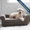 Happy dog lounging on a plush grey sofa bed, labeled as 'Online Exclusive', showcasing luxury pet furniture from HT Animal Supply.